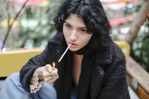 Woman in Black Coat Holding Cigarette Stick