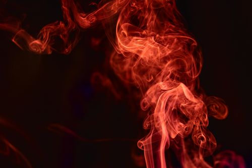 Free Dynamic red smoke art on a dark background in an abstract composition. Stock Photo