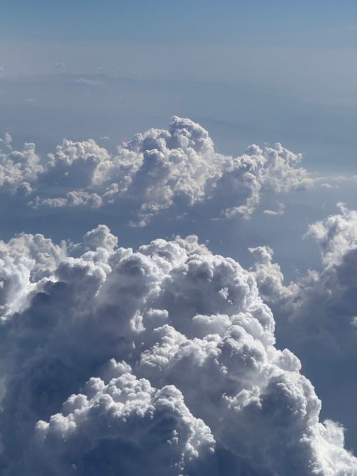 Free A stunning aerial view of towering cumulus and cumulonimbus clouds under a blue sky, perfect for weather visuals. Stock Photo