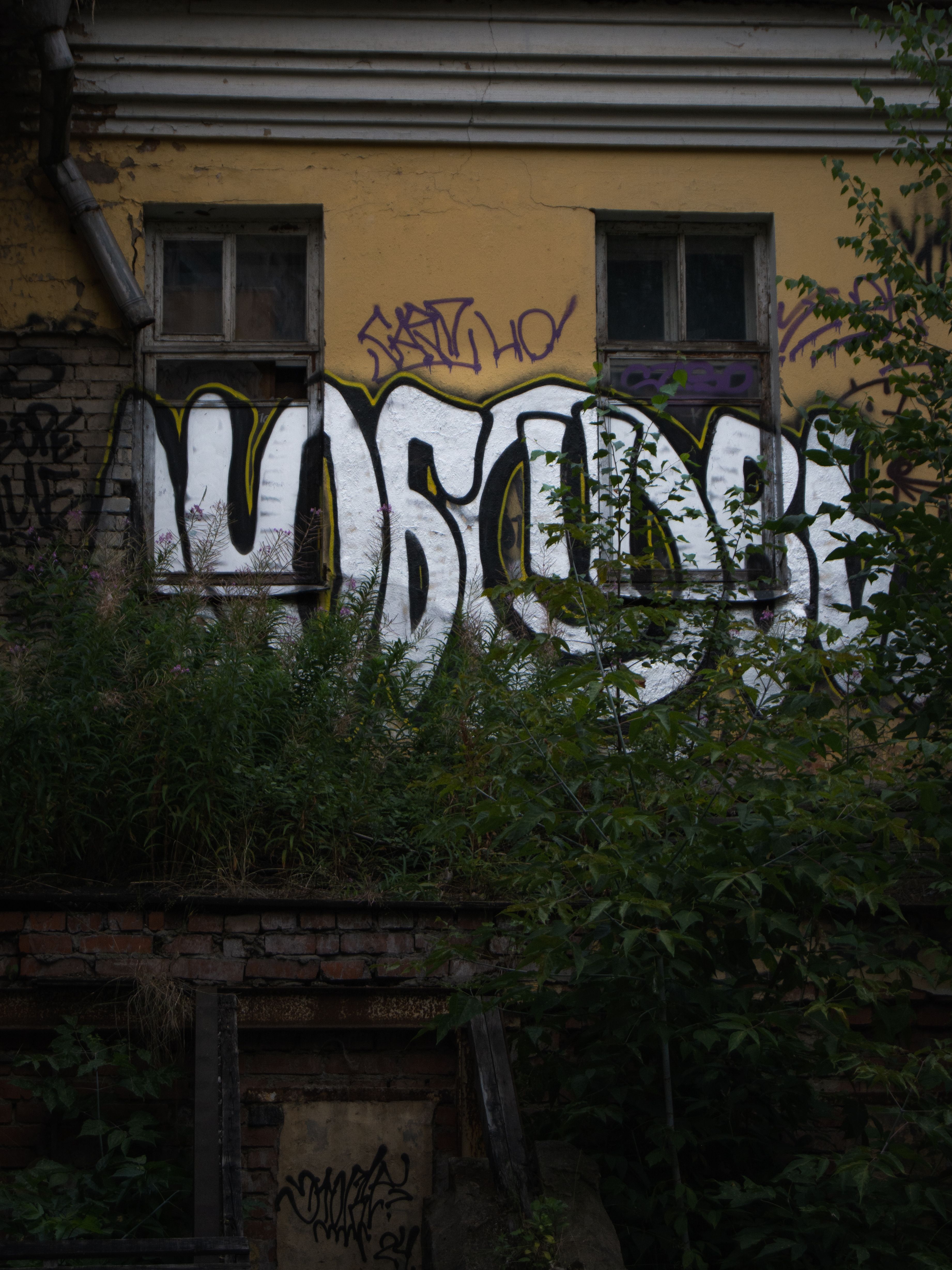 Street art graffiti on an old building wall in Moscow, Russia, showcasing local urban culture.