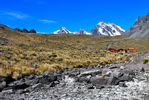 Free Majestic view of mountain peaks with a rugged and grassy foreground under a clear blue sky. Stock Photo