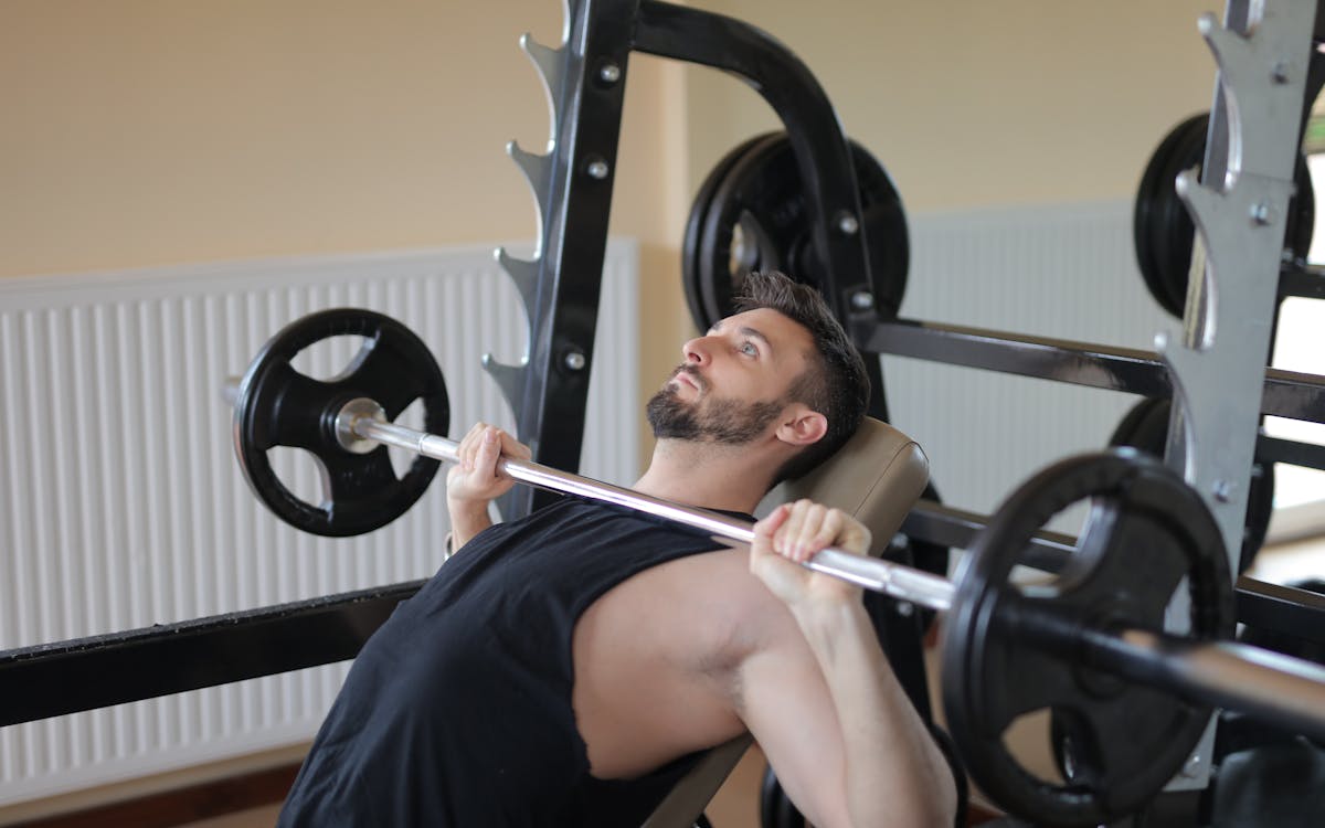 Man in Black Tank Top Holding Black Barbell