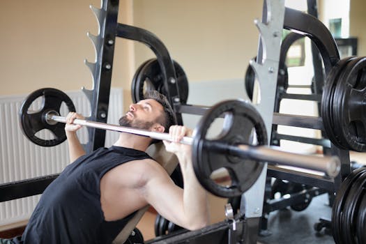 Adult man performing a bench press exercise at the gym, focusing on strength and muscle building.