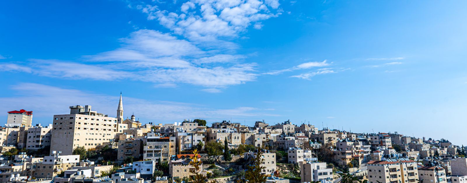Beautiful panoramic view of Bethlehem cityscape under a vibrant blue sky, showcasing historical architecture.