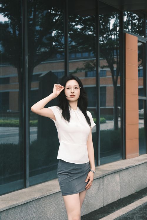 Free A confident woman poses outside a modern building, reflecting urban lifestyle in Xi'an, China. Stock Photo