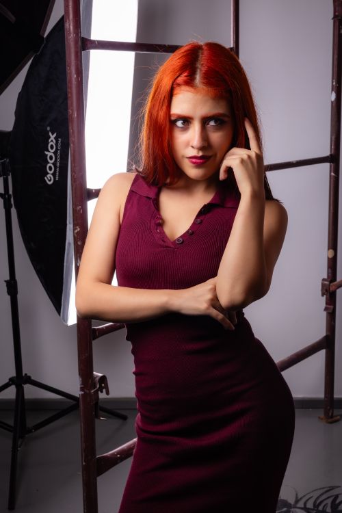 Free Elegant portrait of a woman with red hair in a studio setting with professional lighting equipment. Stock Photo