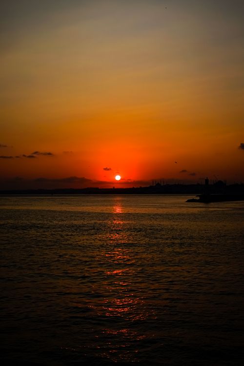 Free Captivating sunset with vibrant hues reflecting on tranquil ocean waters, evoking serenity and calm. Stock Photo