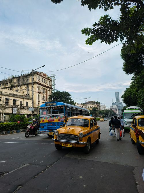 Free Vibrant Kolkata scene featuring vintage yellow taxis and historic architecture. Stock Photo