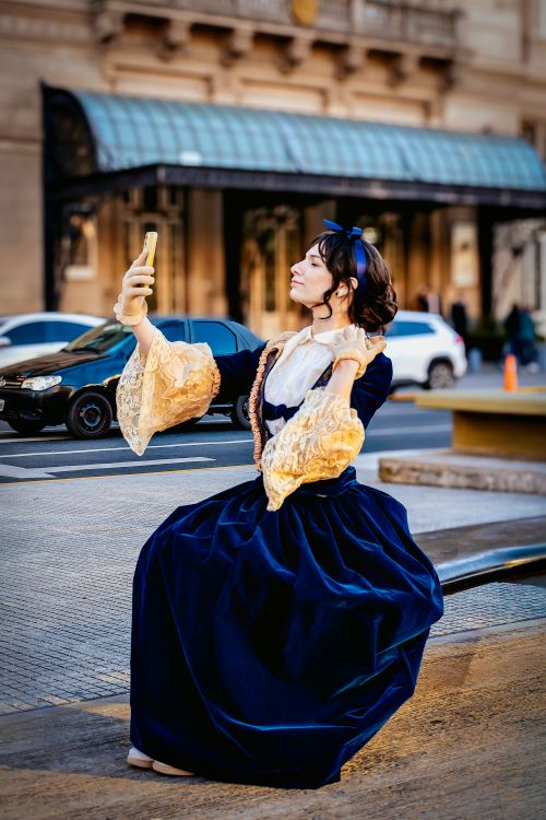 Free Woman dressed in vintage attire takes a selfie in bustling Buenos Aires street. Stock Photo