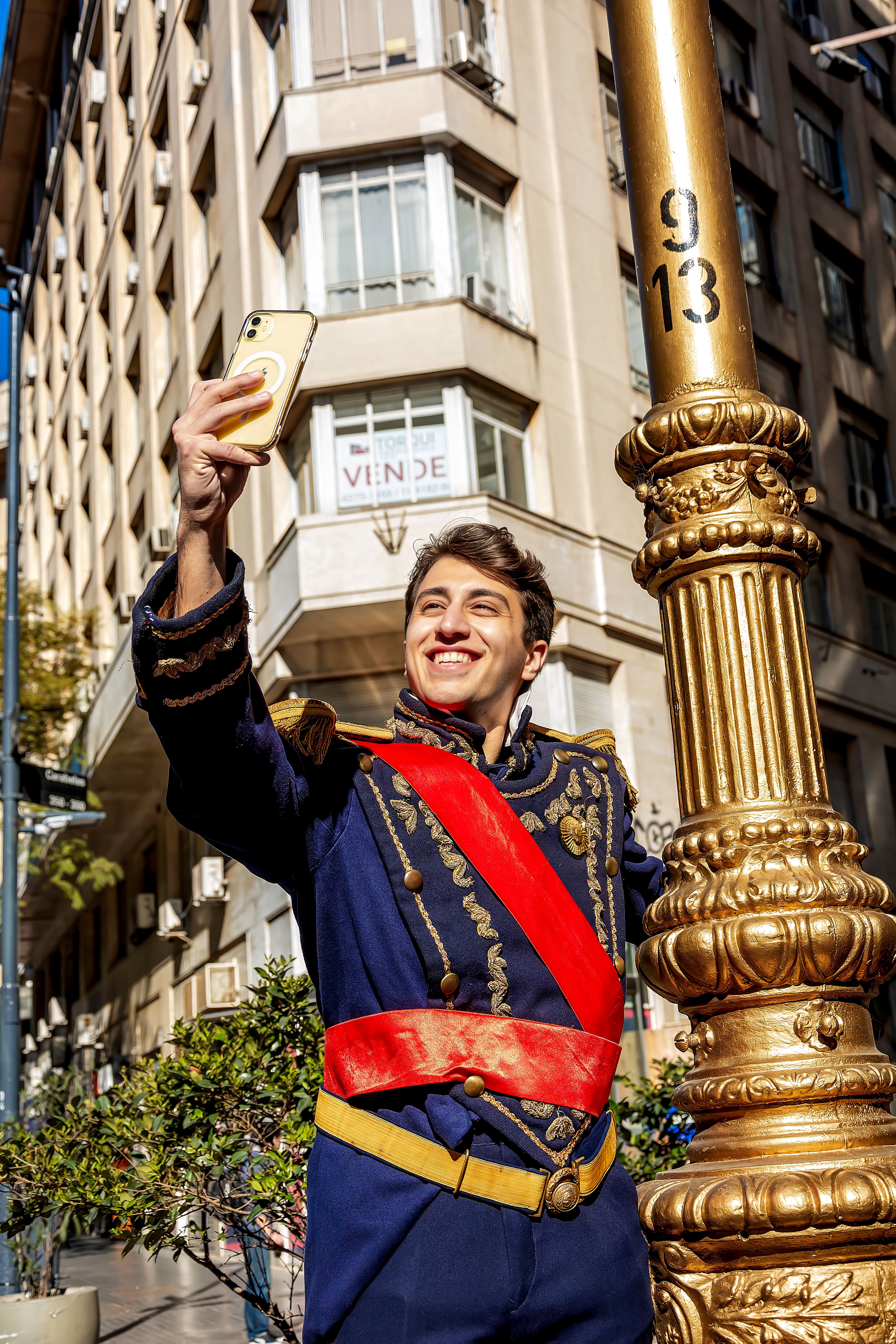 Young man dressed in historical costume taking a selfie outdoors in Buenos Aires, Argentina on a sunny day.