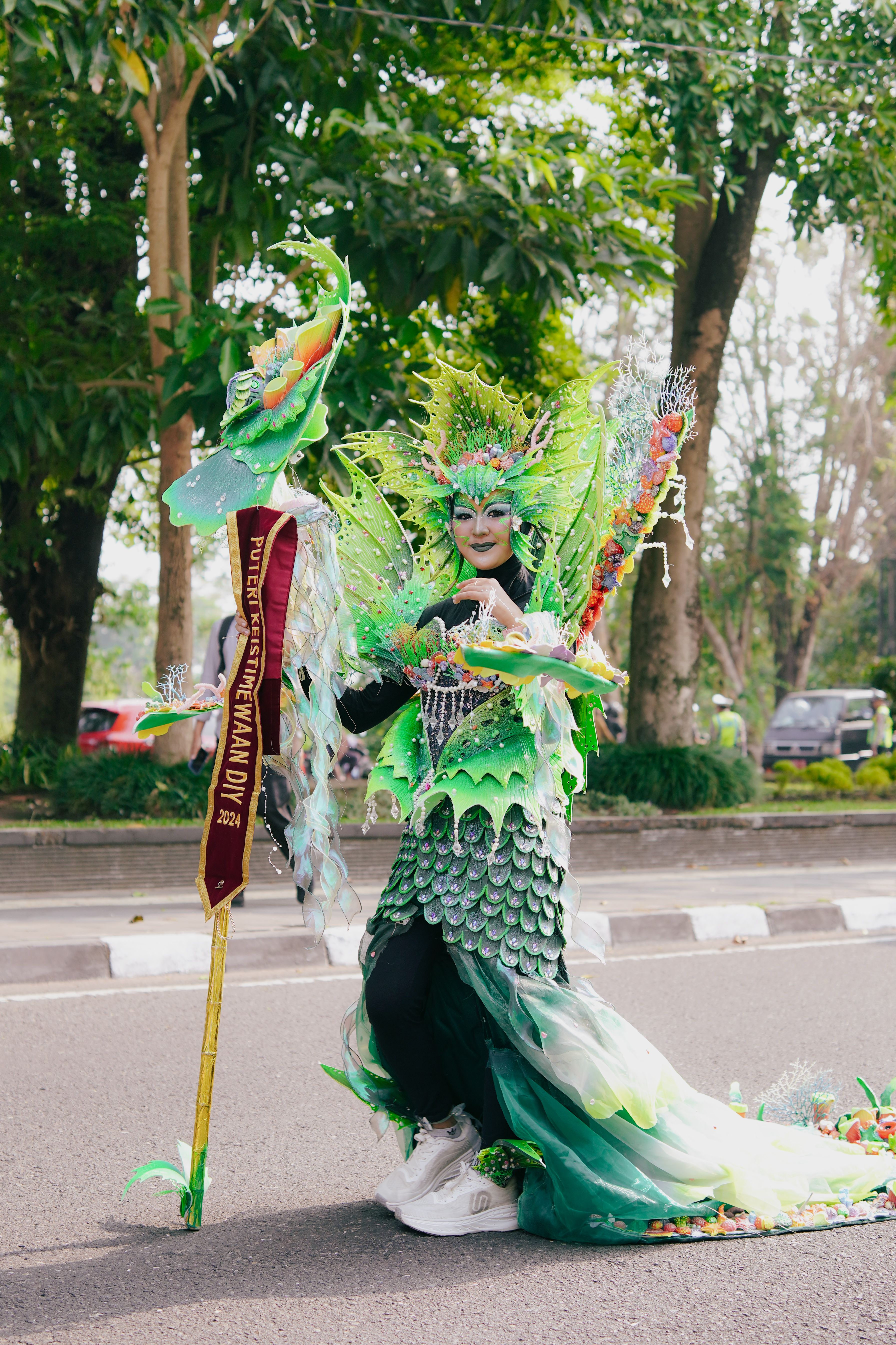 Intricate green costume in a cultural parade, Yogyakarta, Indonesia.
