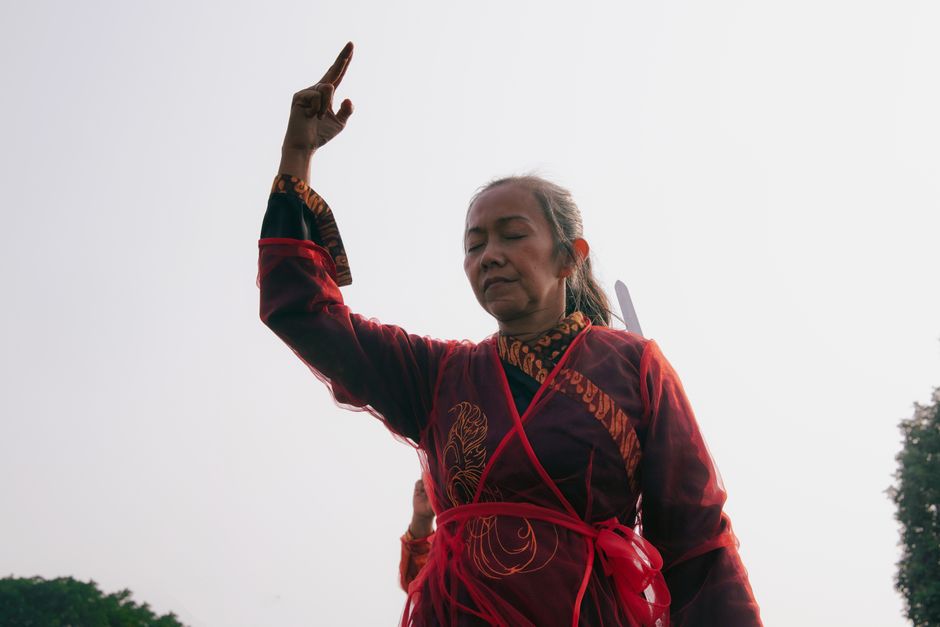 Woman performing Tai Chi in traditional attire in Yogyakarta, Indonesia, showcasing balance and concentration.