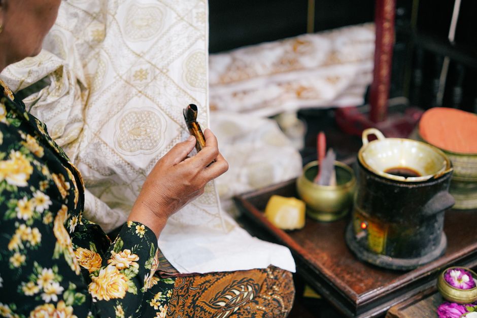 Close-up of a craftswoman creating traditional batik with wax in Yogyakarta, Indonesia.