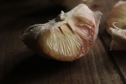 Free Detailed macro shot of a pomelo slice showcasing its juicy segments and textured peel. Stock Photo
