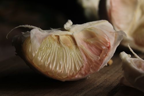 Free Detailed view of a pomelo segment displaying its juicy flesh and textured peel. Stock Photo