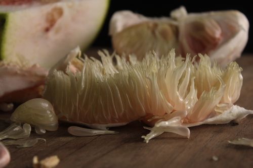 Free Detailed macro shot of a sliced pomelo showing juicy segments on a wooden surface. Stock Photo
