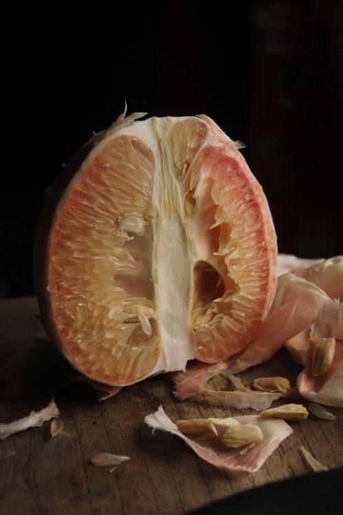 Free Artistic shot of halved grapefruit on a wooden board, showcasing juicy texture. Stock Photo