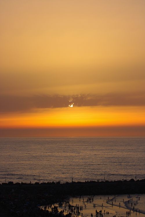 Free Stunning sunset over the Atlantic Ocean at Rabat beach with silhouettes of people enjoying the view. Stock Photo