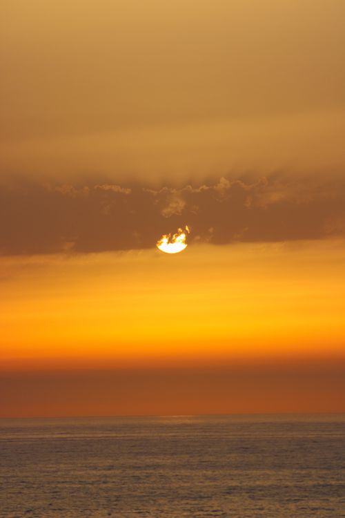 Free Stunning view of a vibrant orange sunset over the ocean in Rabat, Morocco. Stock Photo