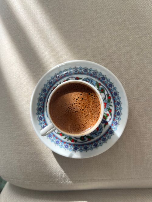 Free Top view of a Turkish coffee cup with decorative saucer bathed in sunlight. Stock Photo