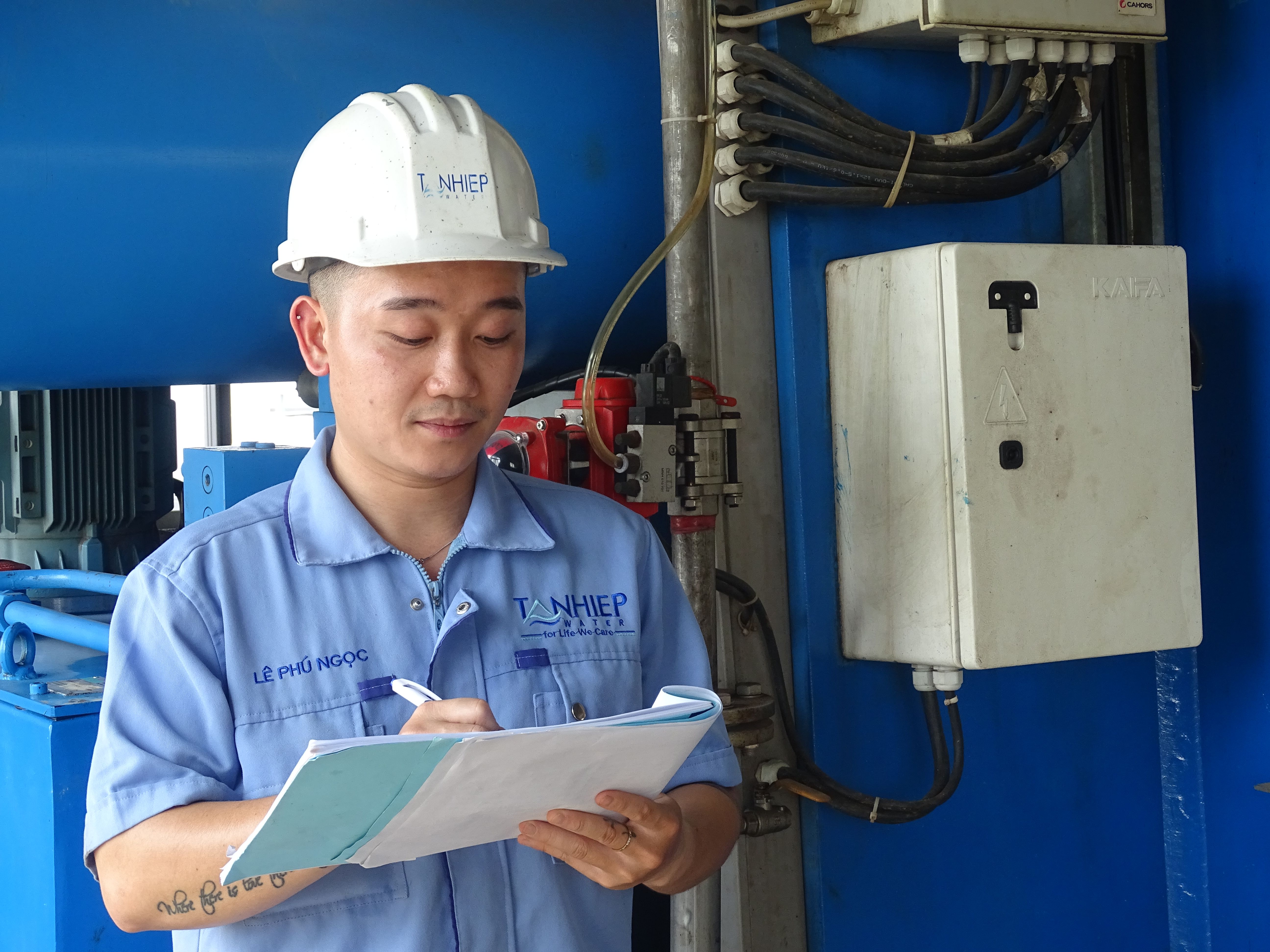 Người xem ghi chép kết quả trận gà trên sổ tay cạnh điện thoại hiển thị bảng tỷ lệ