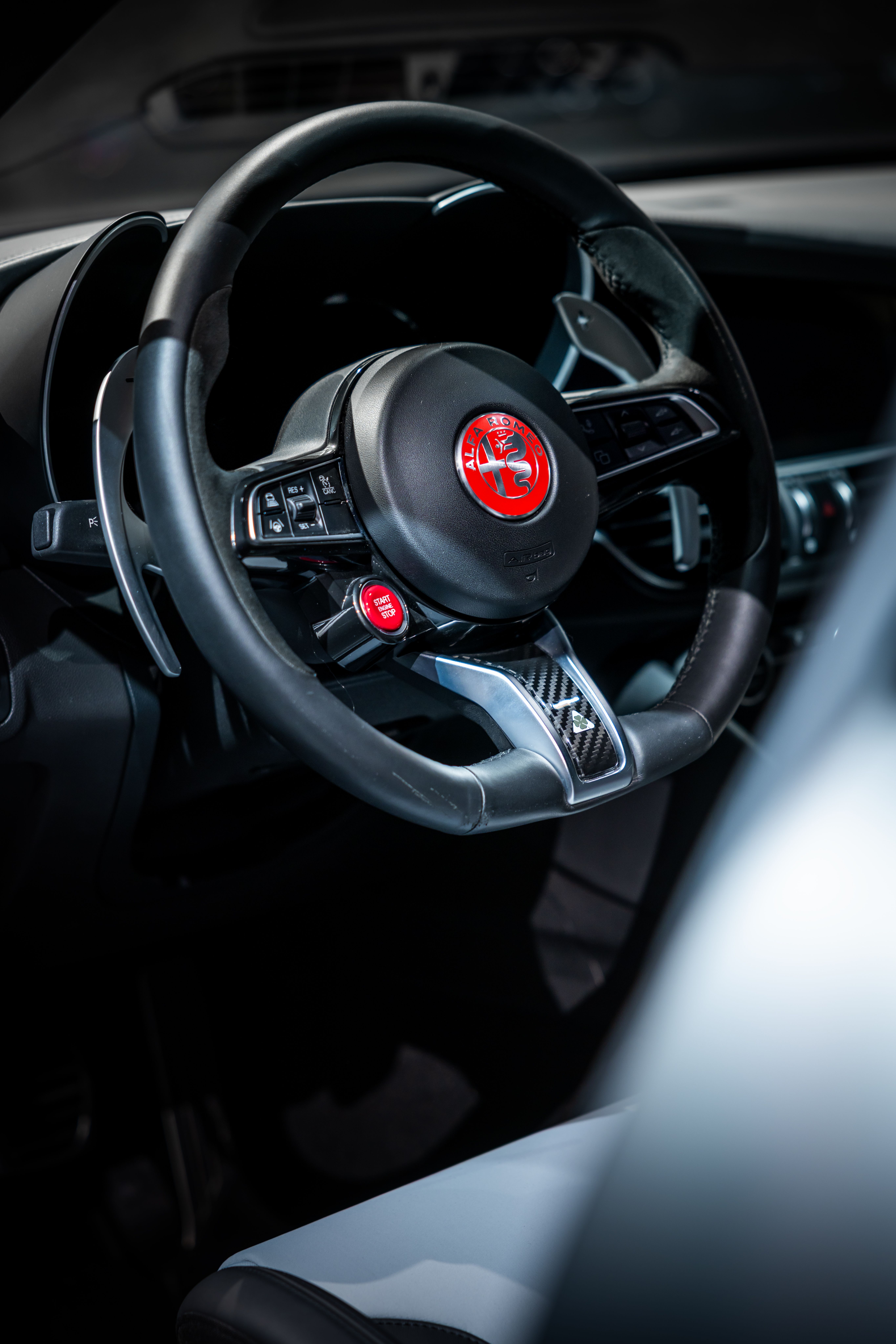Close-up of a luxury car steering wheel interior, showcasing sleek design and detail.