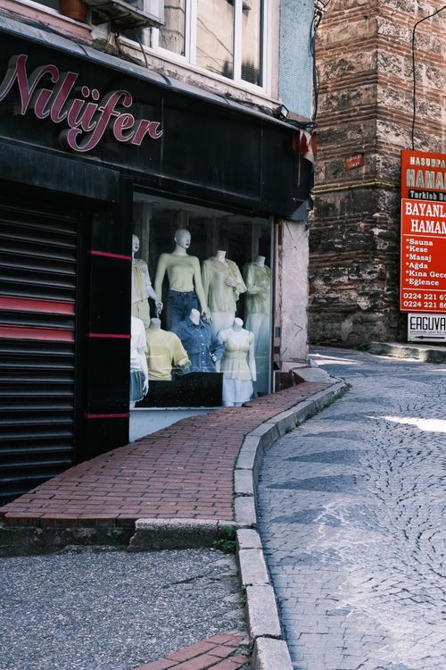 Free Urban street with mannequins in a shop window displaying yellow clothing. Stock Photo