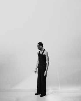 Black and white portrait of a man in a studio setting, embracing minimalist style in Abuja, Nigeria.