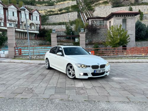 Free White car parked in an open area with a stone building backdrop in Ankara, Turkey. Stock Photo