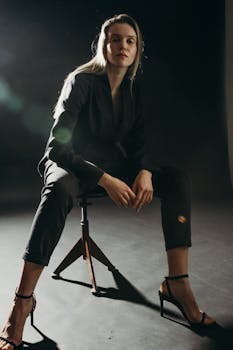 一位优雅的女人穿着时尚的西装外套，自信地坐在工作室里