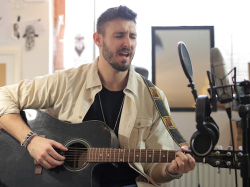 Man in Brown Button Up Shirt Playing Guitar