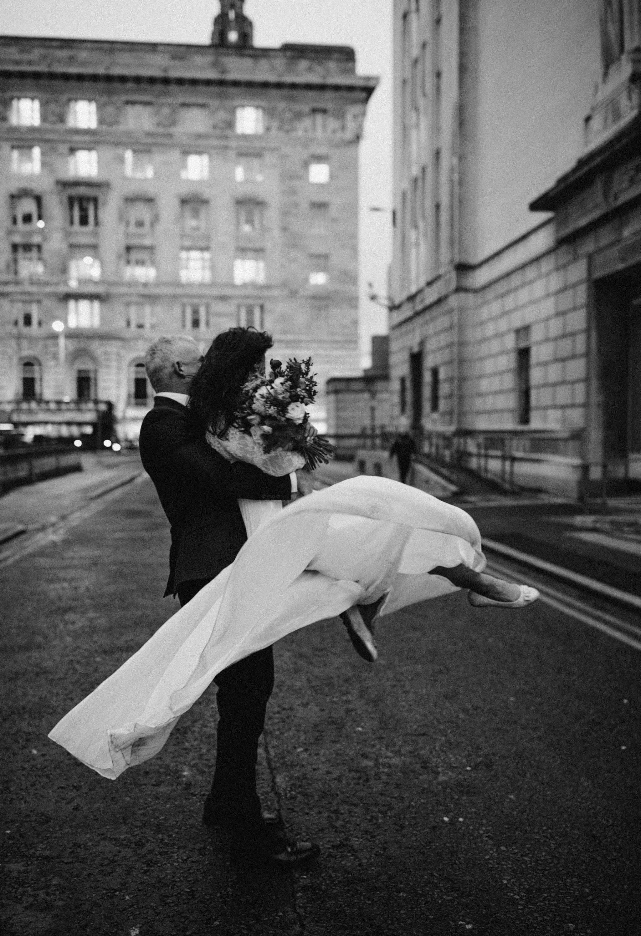 monochrome photo of man carrying woman