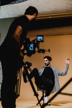 Dynamic studio photo shoot capturing a fashion model and photographer at work.