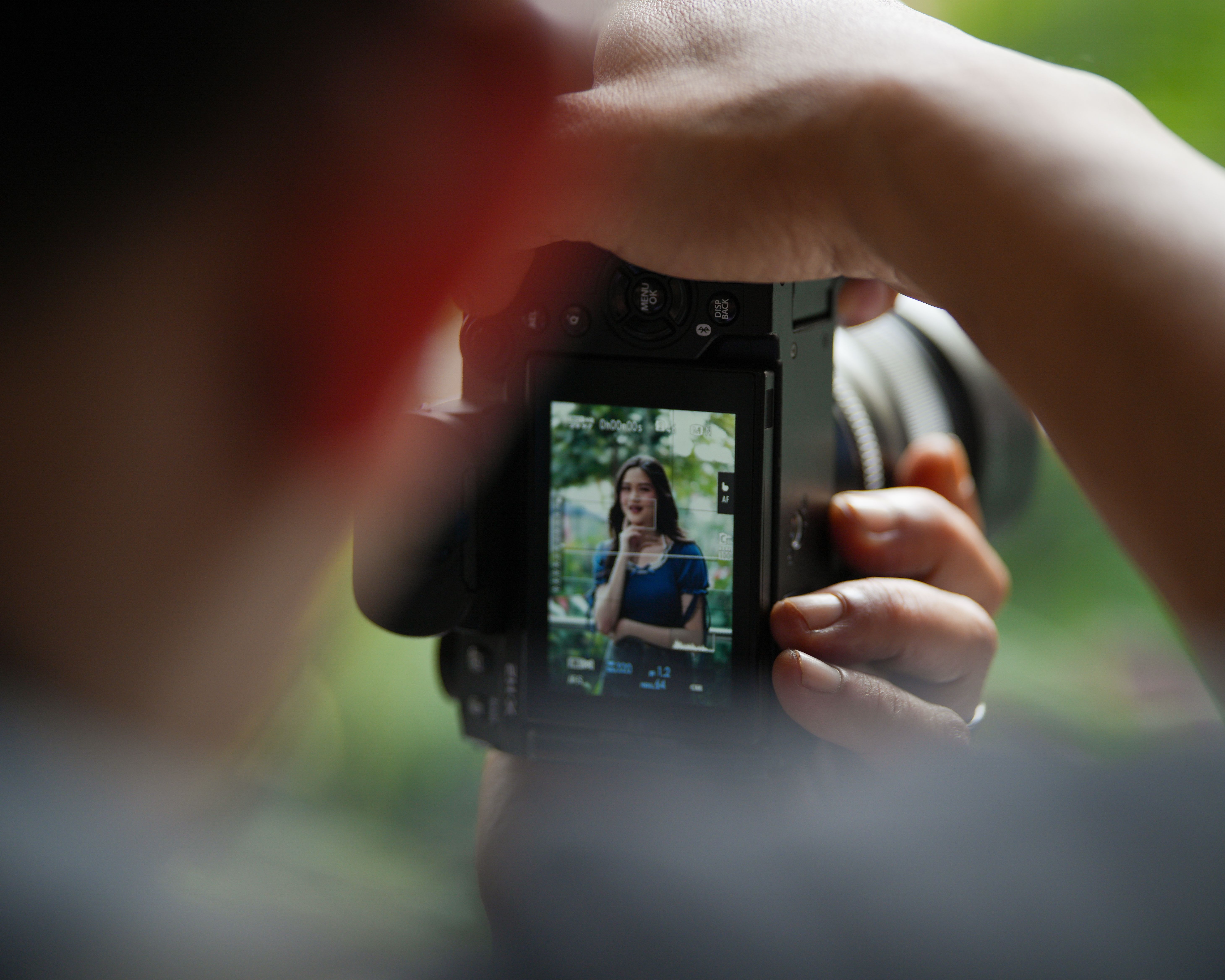 Close-up of a camera viewfinder showing a portrait session outdoors in Jakarta, Indonesia.