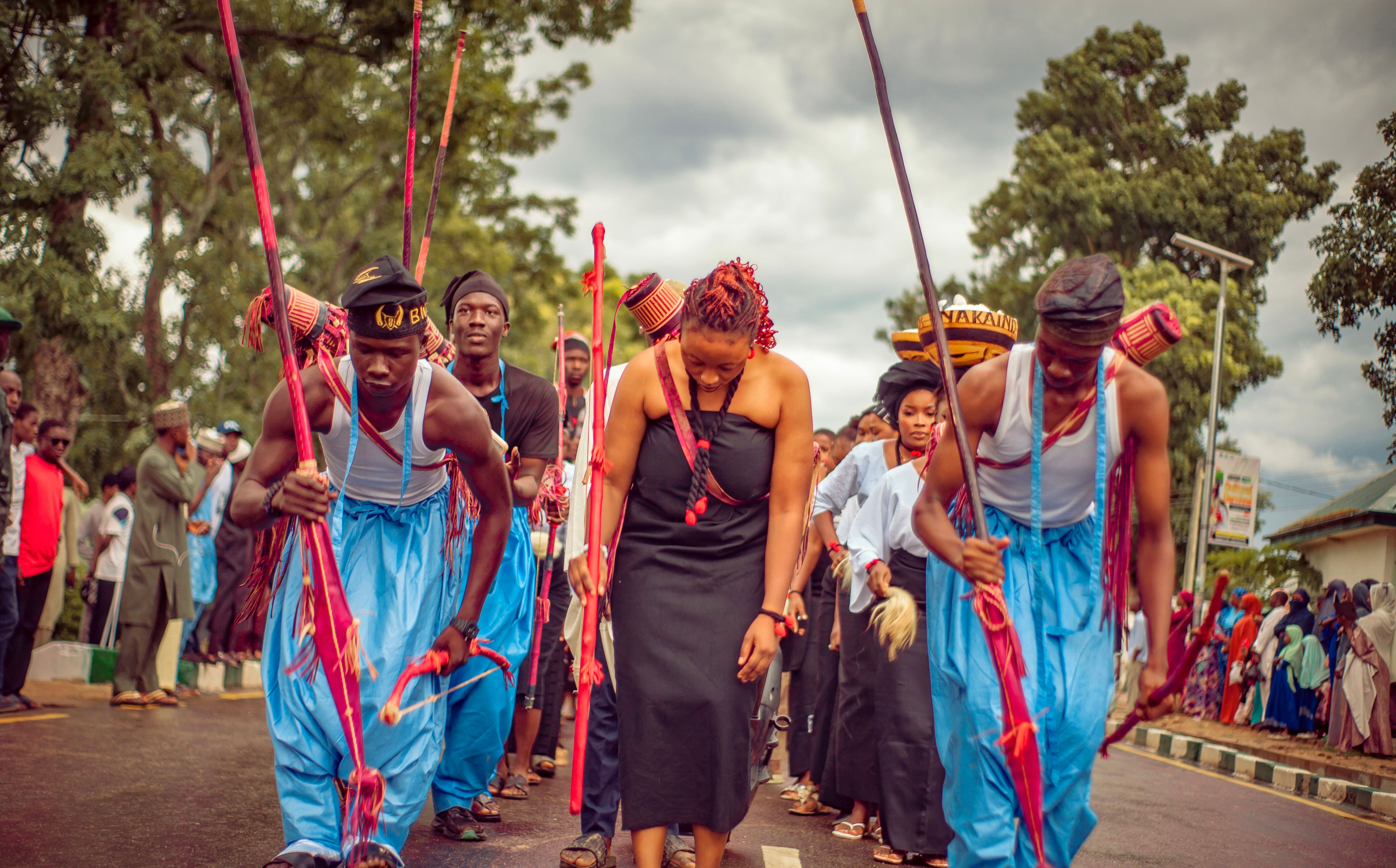 Vibrant cultural dance performance with traditionally dressed dancers holding sticks in an outdoor setting.