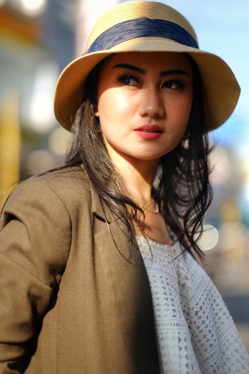 Free Stylish woman wearing a sun hat and blazer in a sunny outdoor setting, Garut, Indonesia. Stock Photo