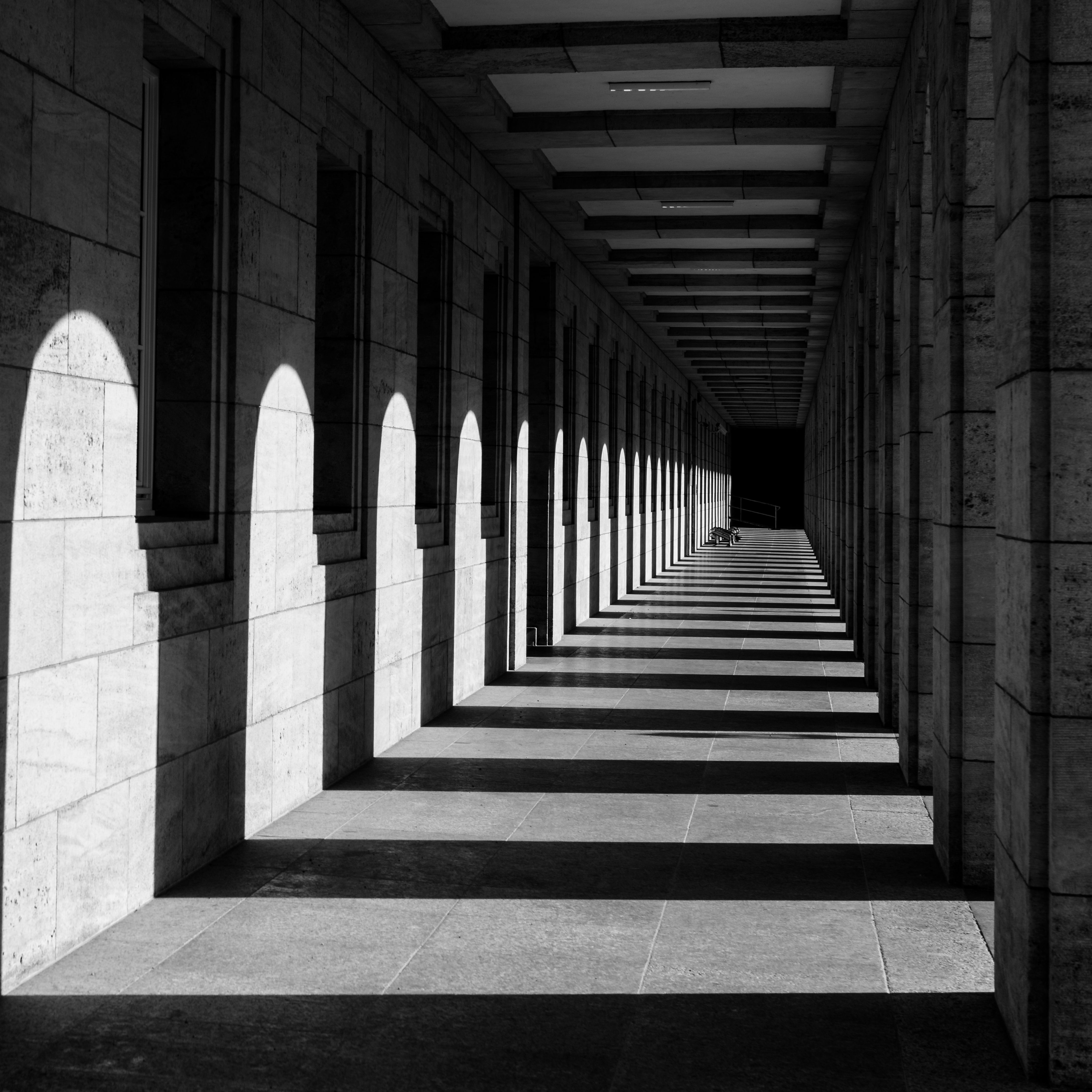 Monochrome view of a shadowed corridor in Weimar, highlighting geometric patterns.