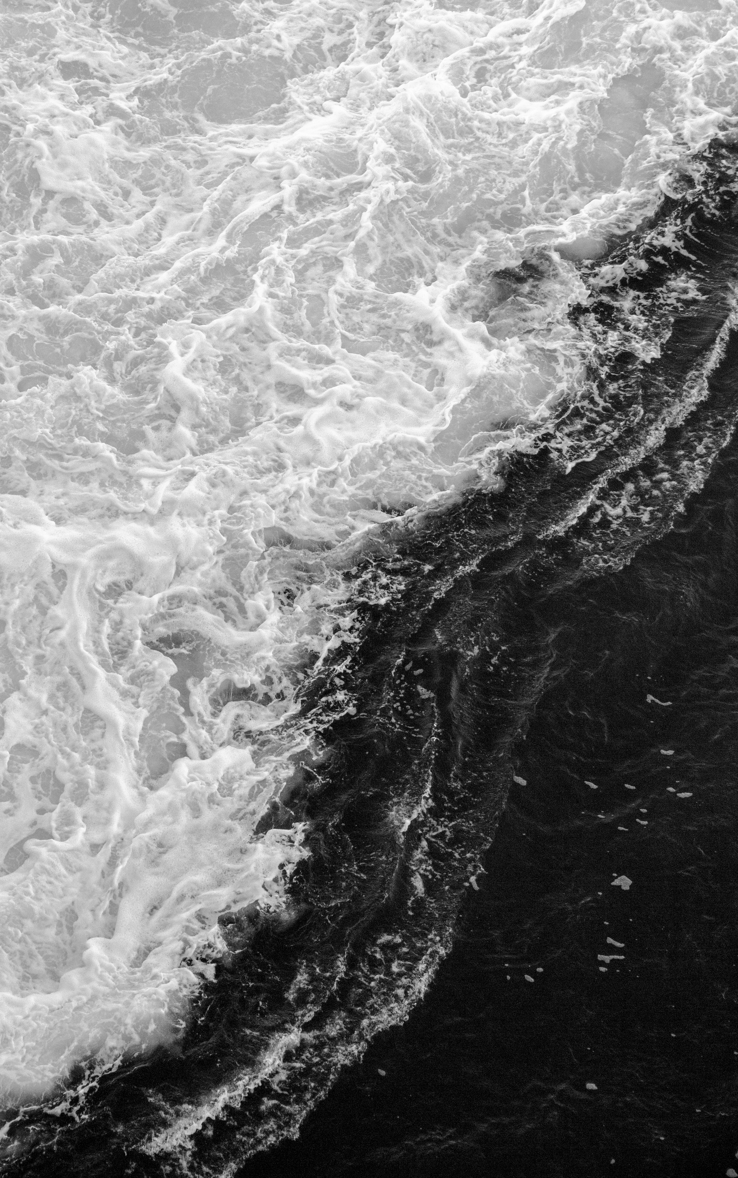 Artistic capture of ocean waves in black and white, showcasing dramatic water movement.
