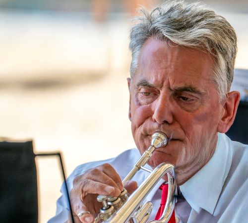 Free Focused portrait of a senior man playing a trumpet, showcasing concentration and skill. Stock Photo