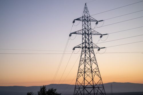 Free High-voltage power lines silhouetted against a vibrant sunset sky in Eskişehir, Türkiye. Stock Photo