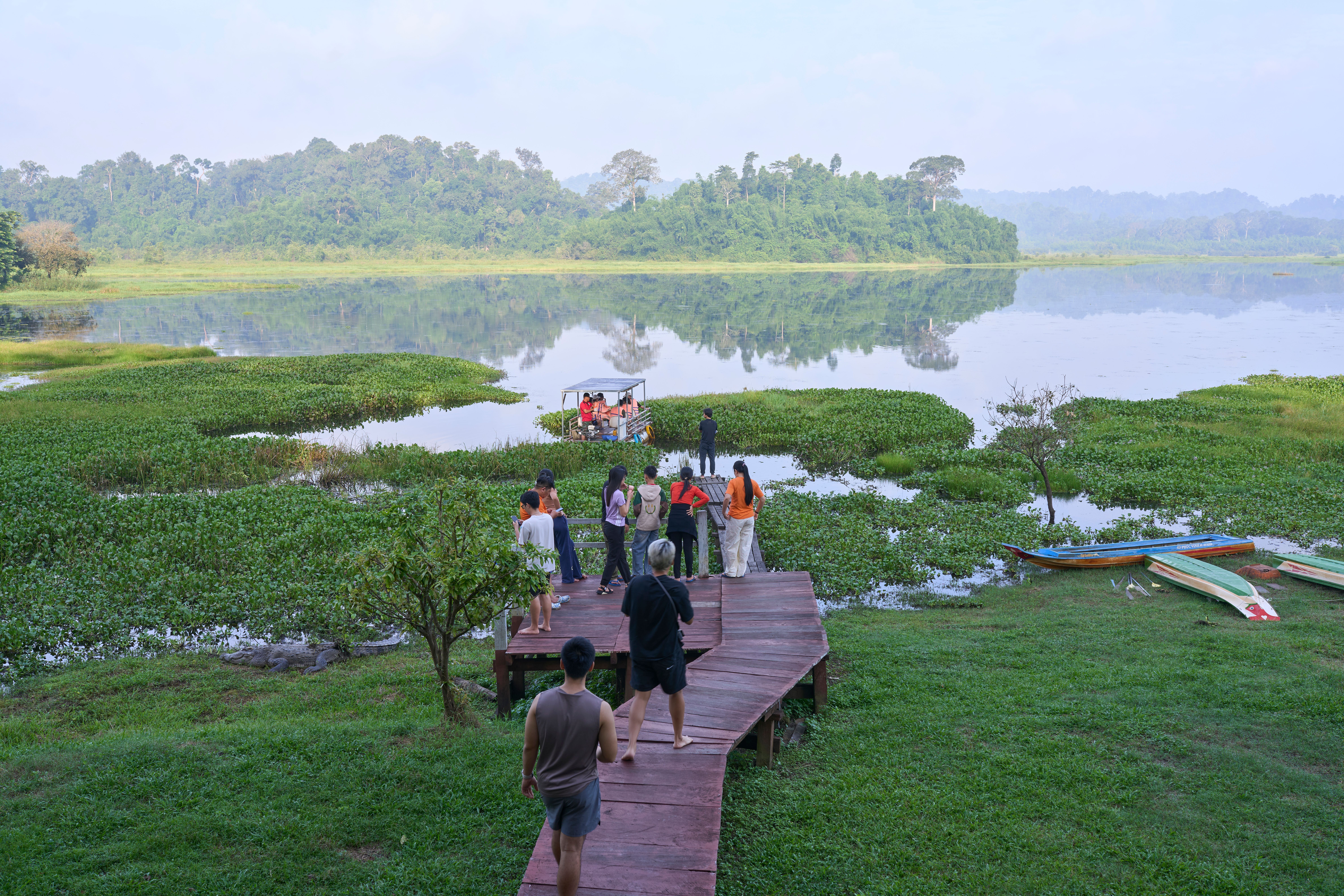 Visitors enjoy a scenic view at the lakeside in Dong Nai City, Vietnam, surrounded by lush nature.