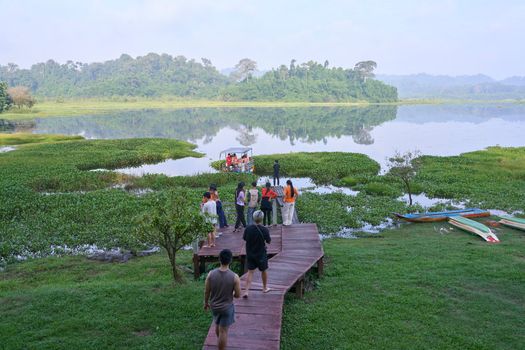 Visitors enjoy a scenic view at the lakeside in Dong Nai City, Vietnam, surrounded by lush nature.