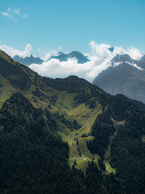 Free Breathtaking aerial shot of lush green mountains in the Swiss Alps during summer. Perfect for travel and nature enthusiasts. Stock Photo