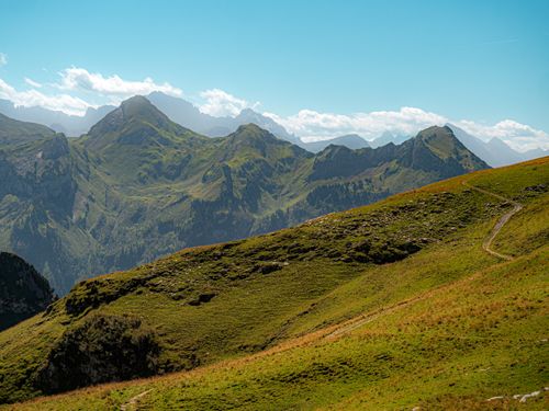 Free Breathtaking view of the Swiss Alps with lush green hills and bright skies. Stock Photo