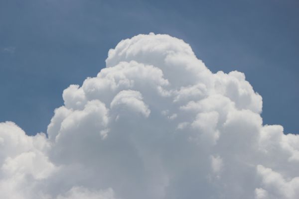 Uma majestosa nuvem cúmulo se eleva contra um céu azul límpido, exibindo a beleza da natureza.