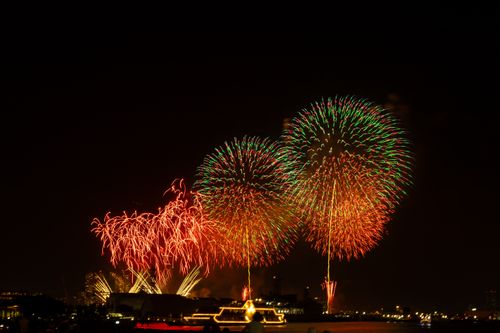 Free Breathtaking fireworks over Yokohama's harbor illuminate the night sky in vibrant colors. Stock Photo