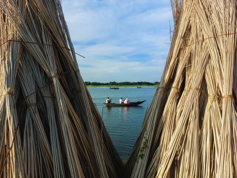 A serene boat ride on a lake framed by bundled reeds under a clear sky.