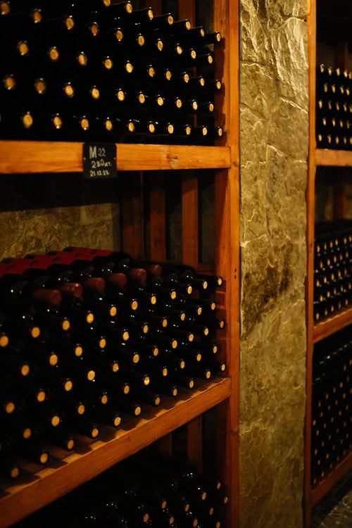 Free A cozy wine cellar filled with neatly arranged wine bottles on wooden shelves. Stock Photo