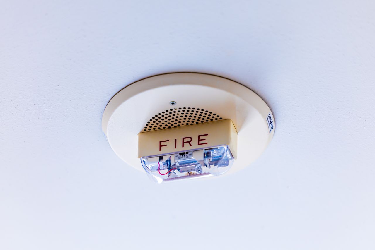A ceiling-mounted alarm unit in a building