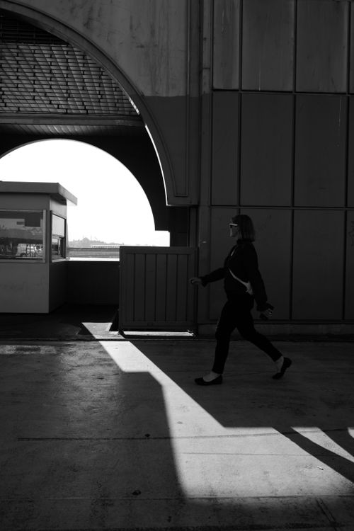 Free A woman walks briskly with a striking shadow in Istanbul, captured in black and white. Stock Photo